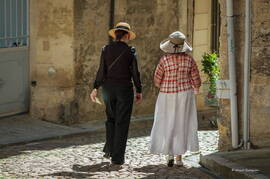 Photo : Tag Avignon - Deux dames aux chapeaux dans la rue ensoleillée