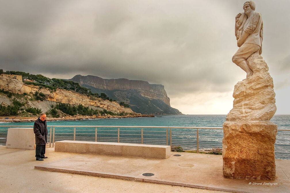 Carnets de Balades - Statue de Calendal La plage de Cassis au premier plan, le statue de Calendal.
Au fond dans la brume le cap Canaille. | GBopassions Photos