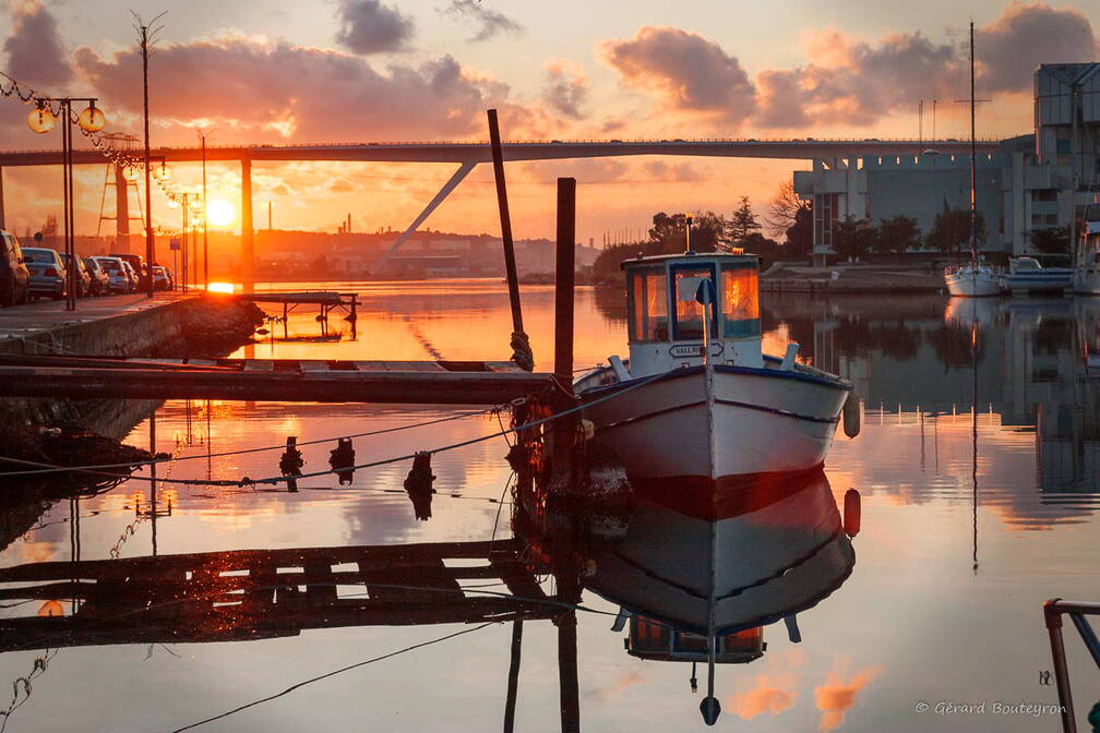 Martigues en photos - Martigues  le canal de baussengues Le soleil se couche sur le canal de baussengue, à droite la mairie de Martigues.
Au fond le pont autoroutier qui enjambe le canal de Caronte pour relier Marseille à Fos sans passer par le centre ville. | GBopassions Photos