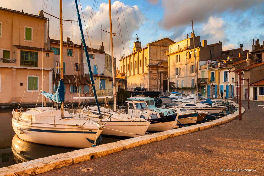 Photo : Martigues en photosPhotos de la ville de Martigues - Couché de soleil sur le miroir aux oiseaux Martigues dans le quartier de l'ile:<br />
le miroir aux oiseaux, un soir d'hiver 2006.<br />
L'église sainte Marie Madeleine est éclairée par le soleil qui se couche sur le canal.